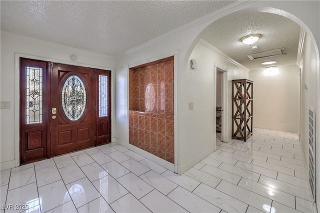 foyer entrance with crown molding and a textured ceiling