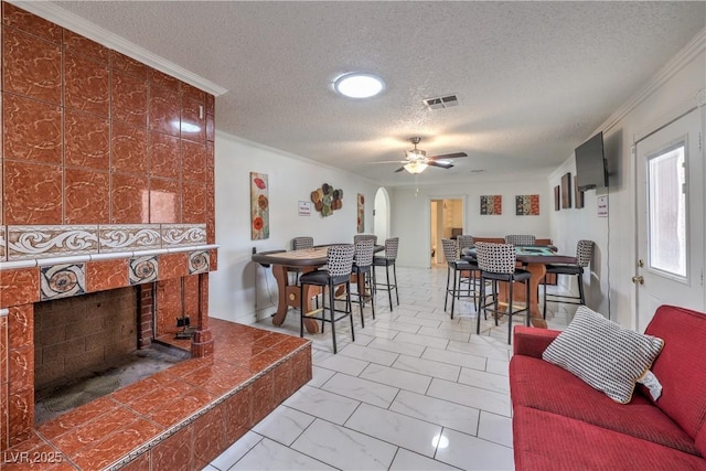 dining space featuring a textured ceiling, ceiling fan, and ornamental molding