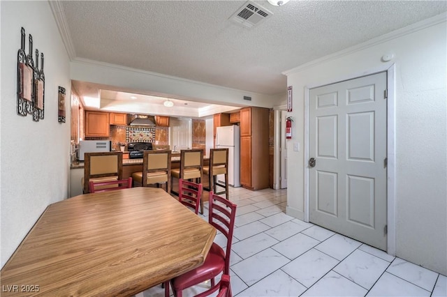 dining area featuring a textured ceiling and ornamental molding