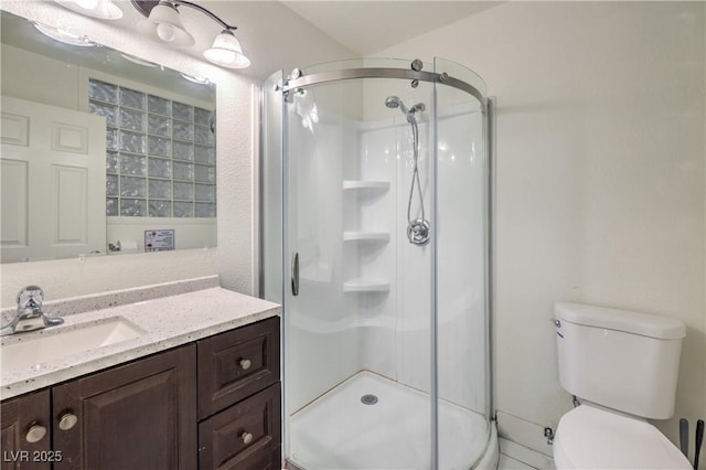 bathroom featuring vanity, toilet, and a shower with shower door