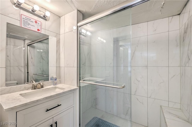 bathroom with toilet, vanity, and walk in shower