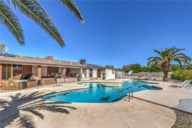 view of swimming pool with an outdoor kitchen, a patio area, and central air condition unit