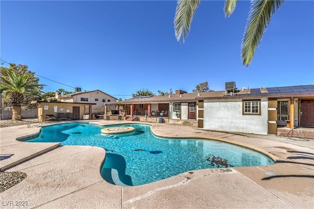 view of pool featuring a jacuzzi, a patio area, and central air condition unit