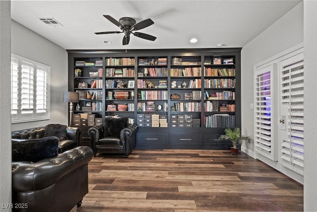 sitting room with wood finished floors, ceiling fan, and visible vents