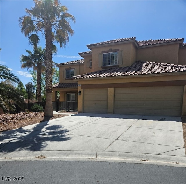 mediterranean / spanish home featuring a tiled roof, concrete driveway, stucco siding, and a garage