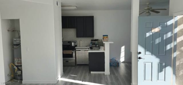 kitchen with dishwasher, stove, dark hardwood / wood-style floors, decorative backsplash, and strapped water heater