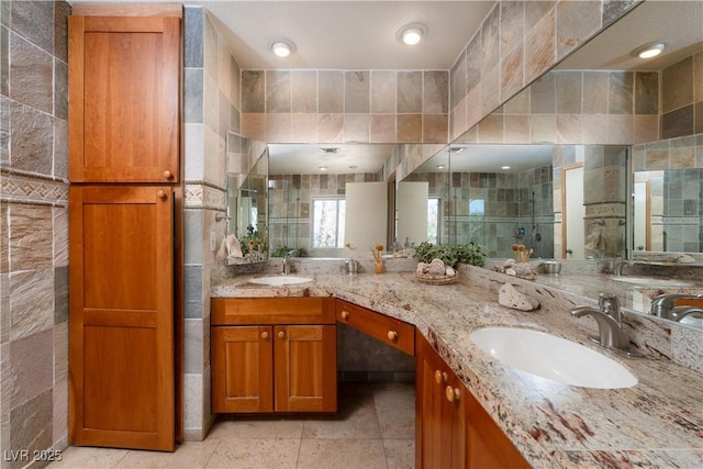 bathroom featuring an enclosed shower, vanity, and tile walls