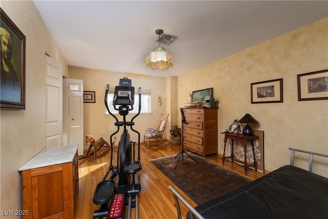 exercise room with light hardwood / wood-style floors