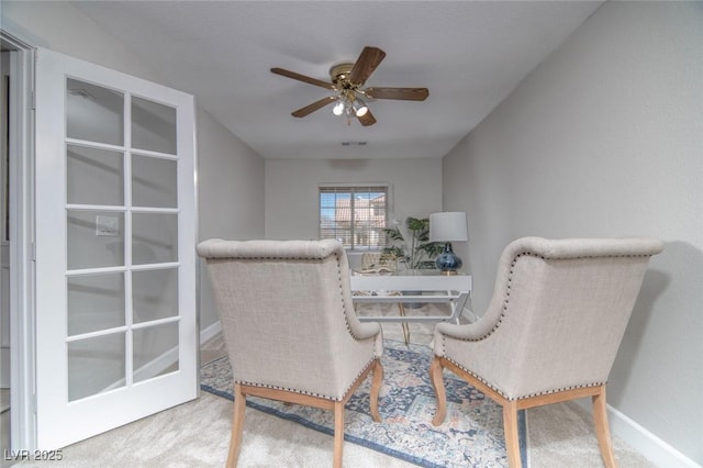 living area featuring carpet flooring and ceiling fan