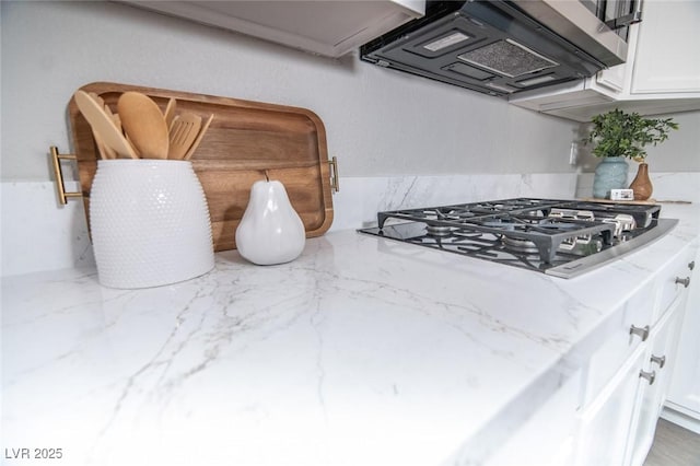 room details with white cabinetry, light stone countertops, extractor fan, and gas cooktop