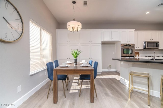 dining space featuring sink and light wood-type flooring