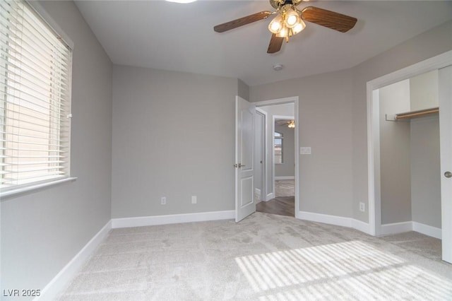 unfurnished bedroom featuring ceiling fan, light carpet, and a closet