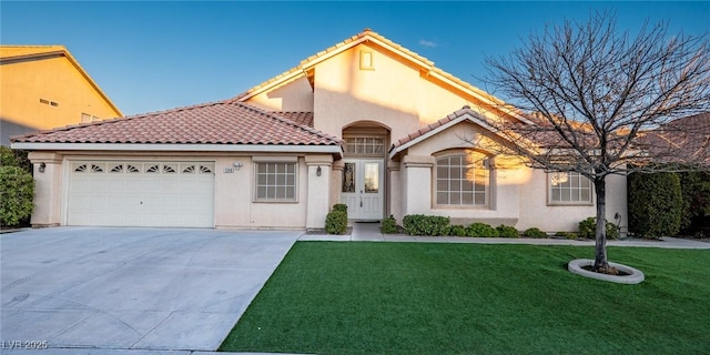 mediterranean / spanish-style home with a front yard and a garage