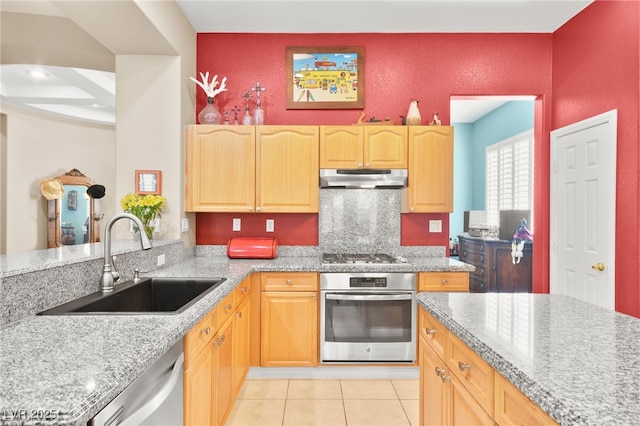 kitchen with light stone countertops, light tile patterned floors, sink, and appliances with stainless steel finishes