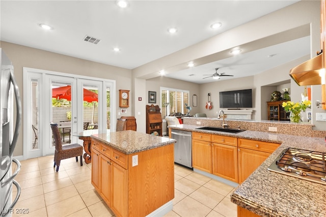 kitchen with appliances with stainless steel finishes, a center island, french doors, and sink