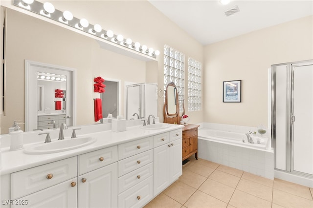 bathroom with tile patterned floors, vanity, and shower with separate bathtub