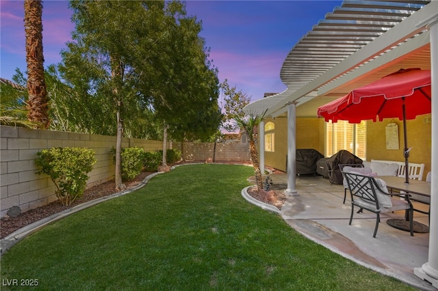 yard at dusk featuring a patio area