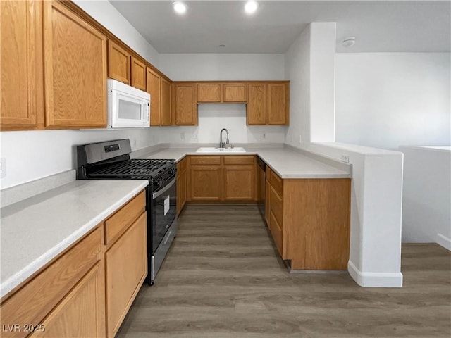 kitchen with light hardwood / wood-style flooring, stainless steel range with gas cooktop, and sink