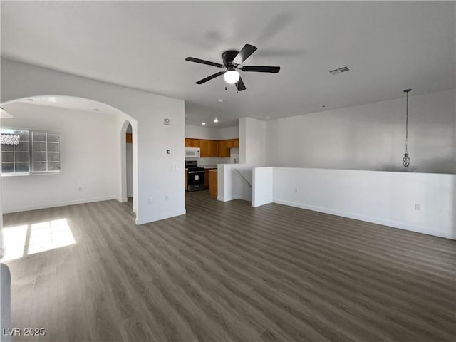 unfurnished living room featuring dark hardwood / wood-style floors and ceiling fan with notable chandelier