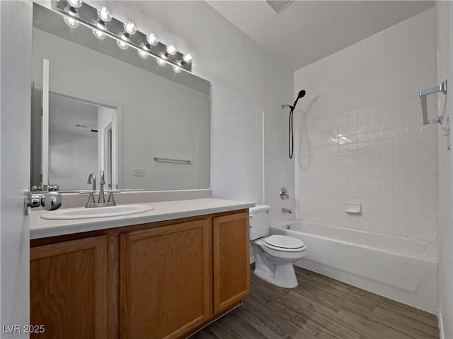 full bathroom with vanity, wood-type flooring, shower / bathtub combination, and toilet