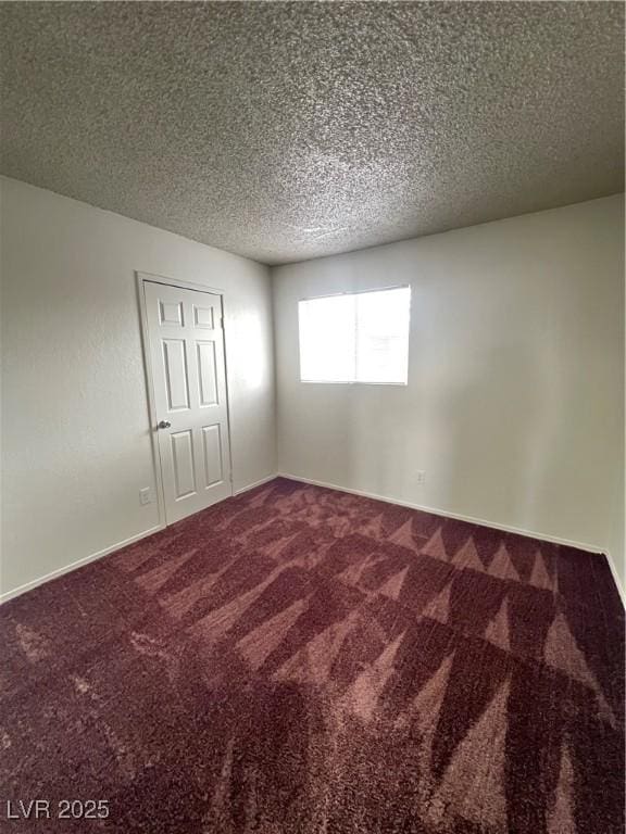 unfurnished room featuring carpet flooring and a textured ceiling