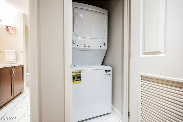 laundry room featuring light tile patterned floors and stacked washer and clothes dryer