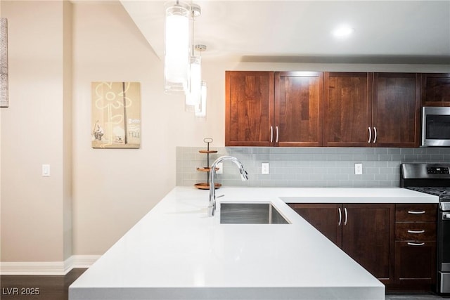 kitchen featuring sink, stainless steel appliances, tasteful backsplash, dark hardwood / wood-style flooring, and pendant lighting