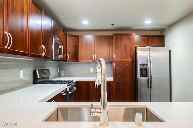 kitchen featuring sink, backsplash, and appliances with stainless steel finishes