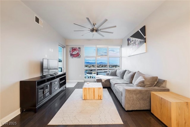 living room featuring ceiling fan and dark wood-type flooring