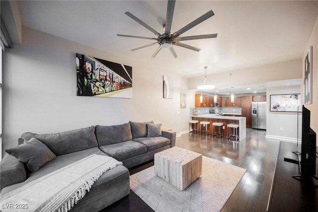 living room with ceiling fan and dark hardwood / wood-style flooring