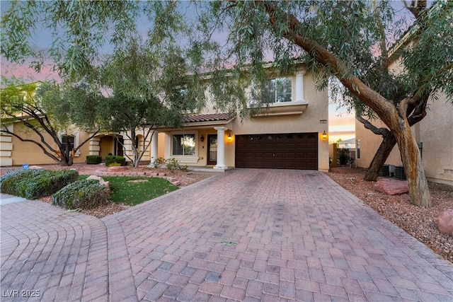 mediterranean / spanish house with central AC unit and a garage