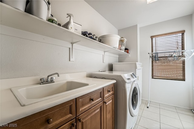 laundry area with sink, independent washer and dryer, light tile patterned floors, and cabinets