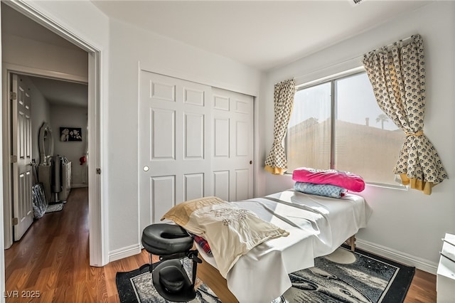 bedroom with dark hardwood / wood-style flooring and a closet