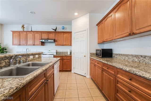 kitchen featuring light tile patterned flooring, white appliances, light stone countertops, and sink