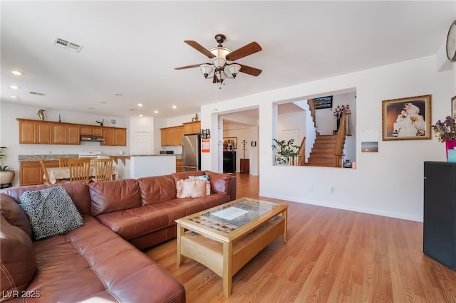 living room featuring light hardwood / wood-style flooring and ceiling fan