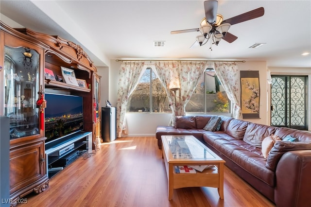 living room featuring ceiling fan and light wood-type flooring