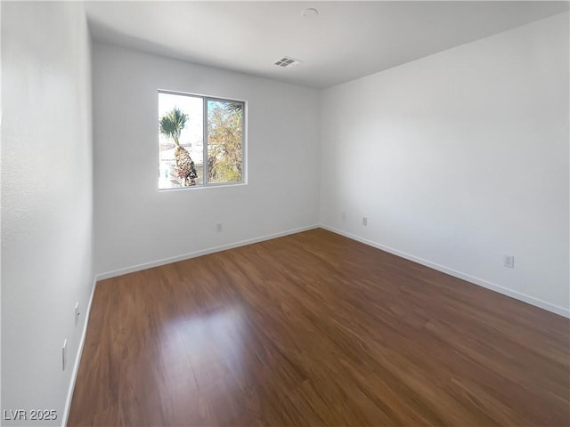 spare room with dark wood-type flooring