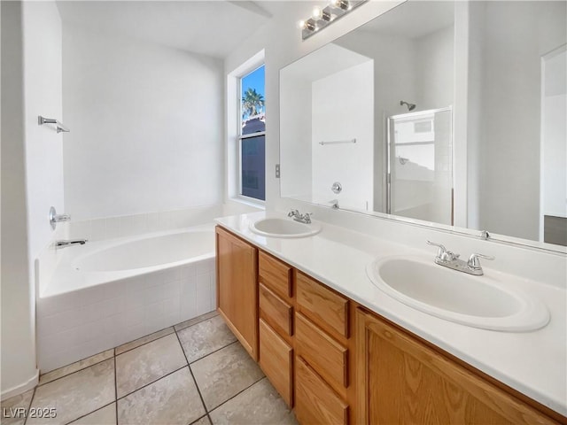 bathroom with tile patterned flooring, vanity, and a relaxing tiled tub