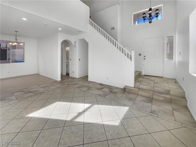 tiled entryway with a chandelier