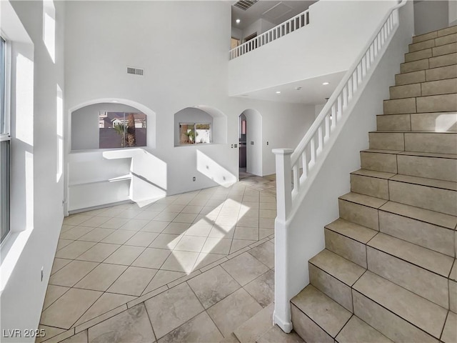 foyer entrance featuring light tile patterned floors and a high ceiling