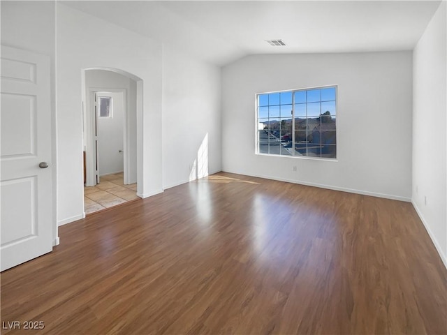 empty room featuring light wood-type flooring and lofted ceiling