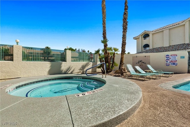 view of swimming pool featuring a patio area and a hot tub