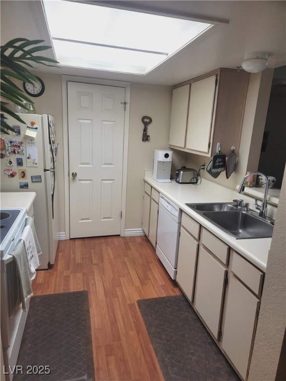 kitchen with white cabinetry, white appliances, sink, and light hardwood / wood-style flooring