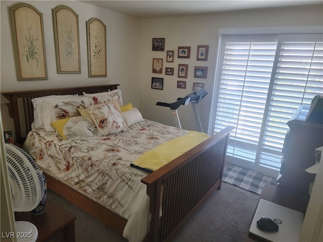 bedroom featuring dark colored carpet and multiple windows