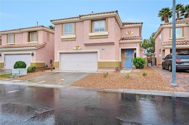 mediterranean / spanish house with stucco siding, concrete driveway, an attached garage, and a tile roof