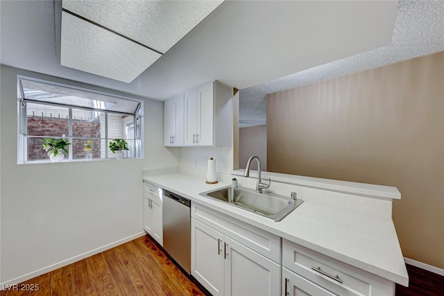 kitchen featuring dishwasher, kitchen peninsula, white cabinetry, and sink