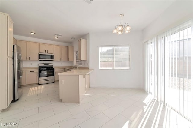 kitchen featuring light brown cabinetry, sink, an inviting chandelier, decorative light fixtures, and stainless steel appliances