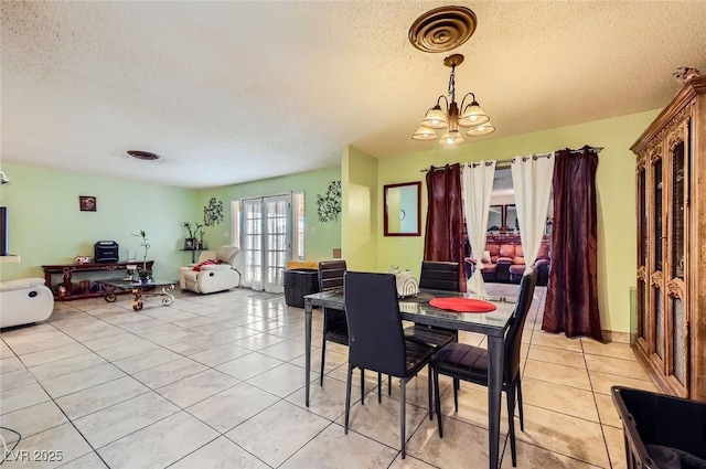 dining area with light tile patterned floors, visible vents, and a textured ceiling