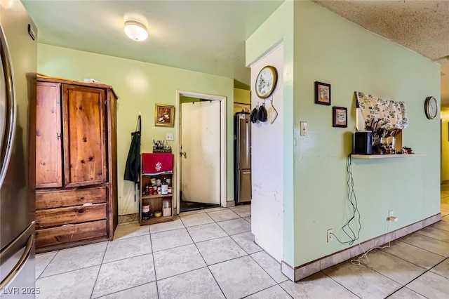 hall with light tile patterned floors and baseboards