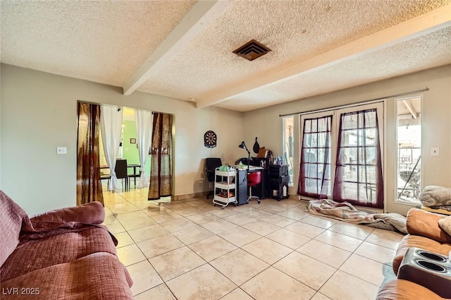 living room with beamed ceiling, light tile patterned flooring, visible vents, and a textured ceiling